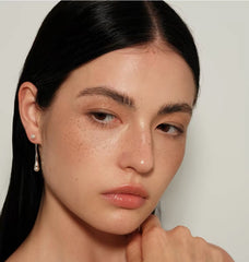 Model wearing Perle Fluide drop earrings, close beauty portrait