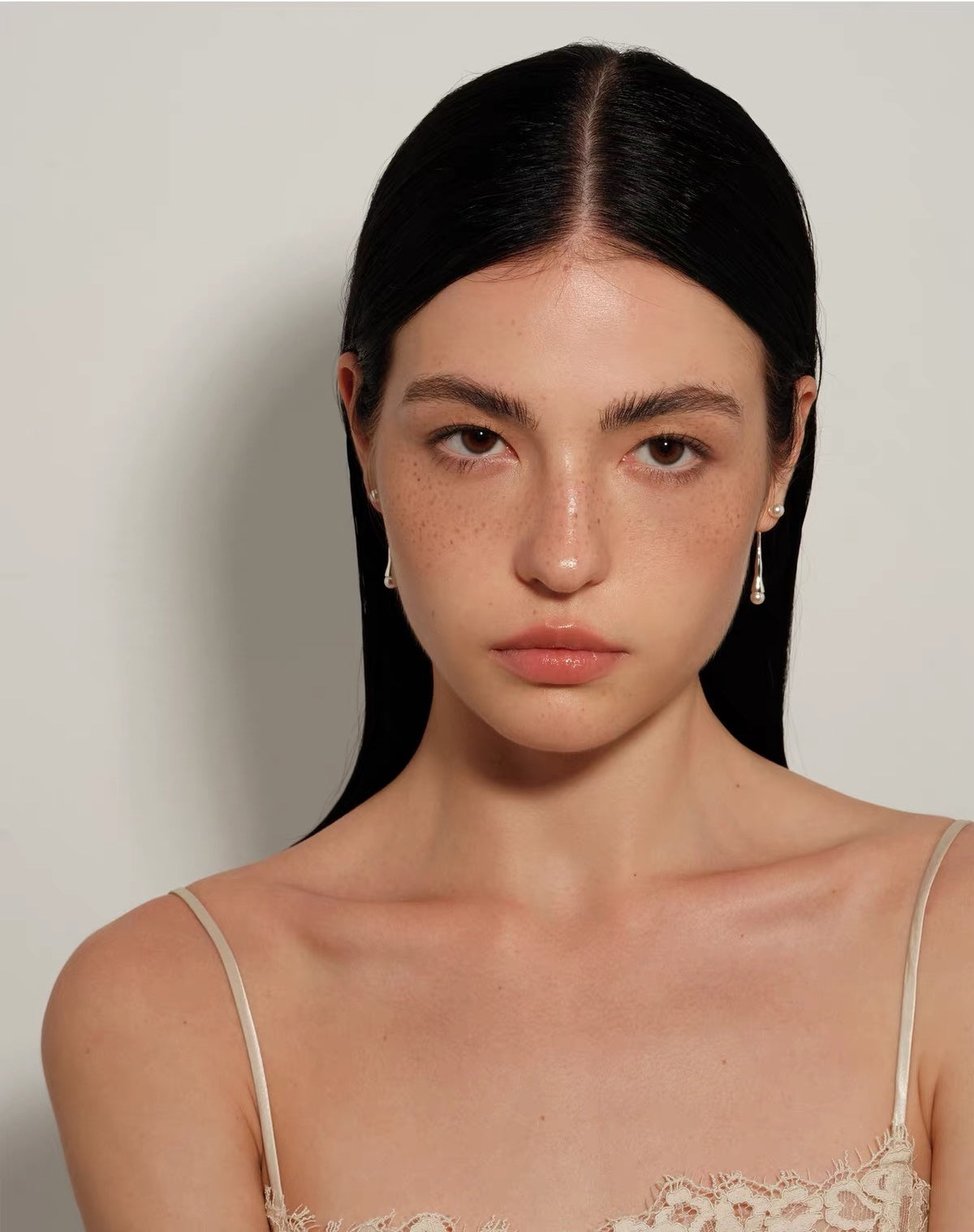 Model wearing Perle Fluide drop earrings, front portrait