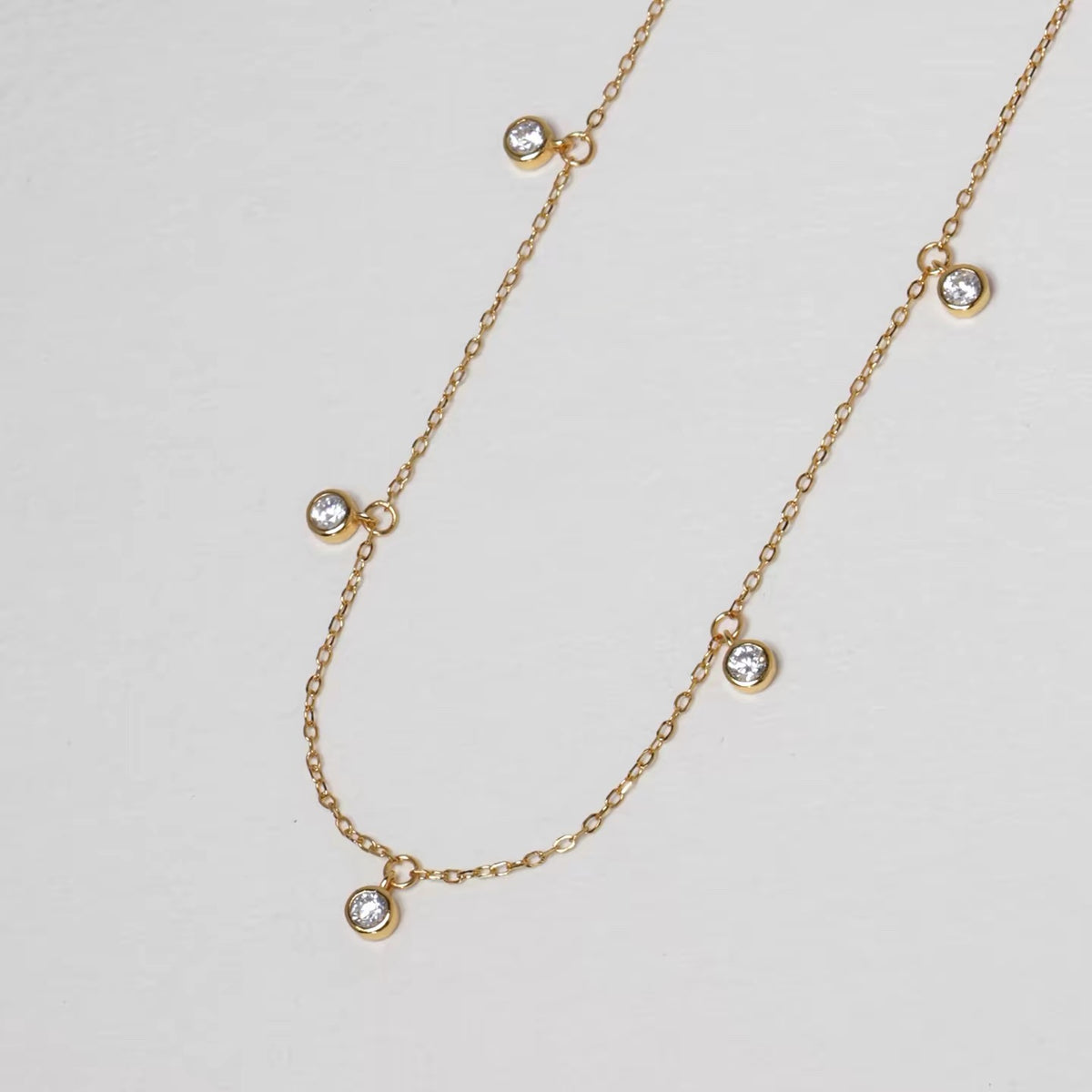 Pluie de Lumière Necklace in gold with five bezel-set zirconia drops